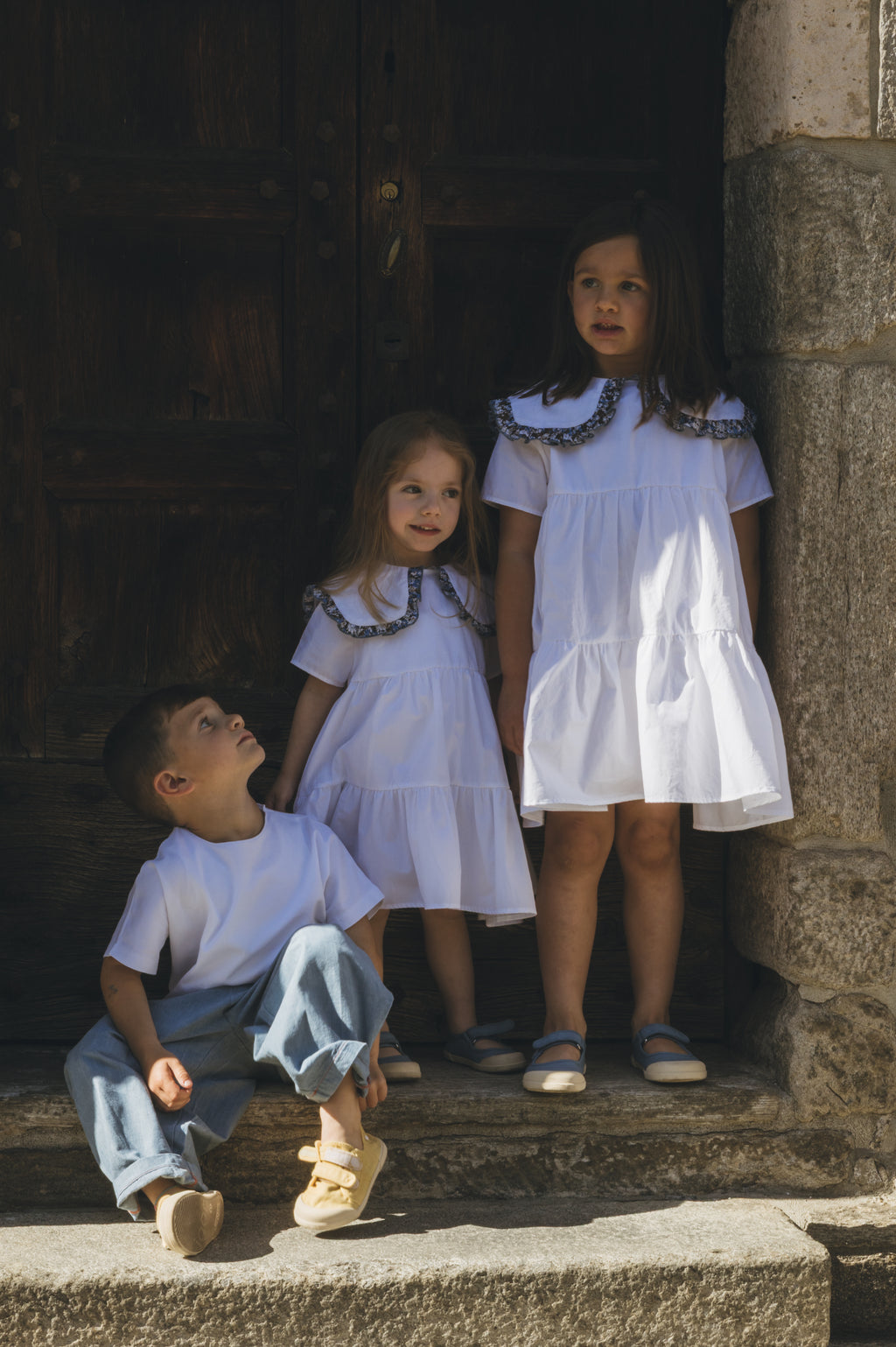 Bambine indossano l'abitino bianco Meringa di Amtea per una cerimonia estiva